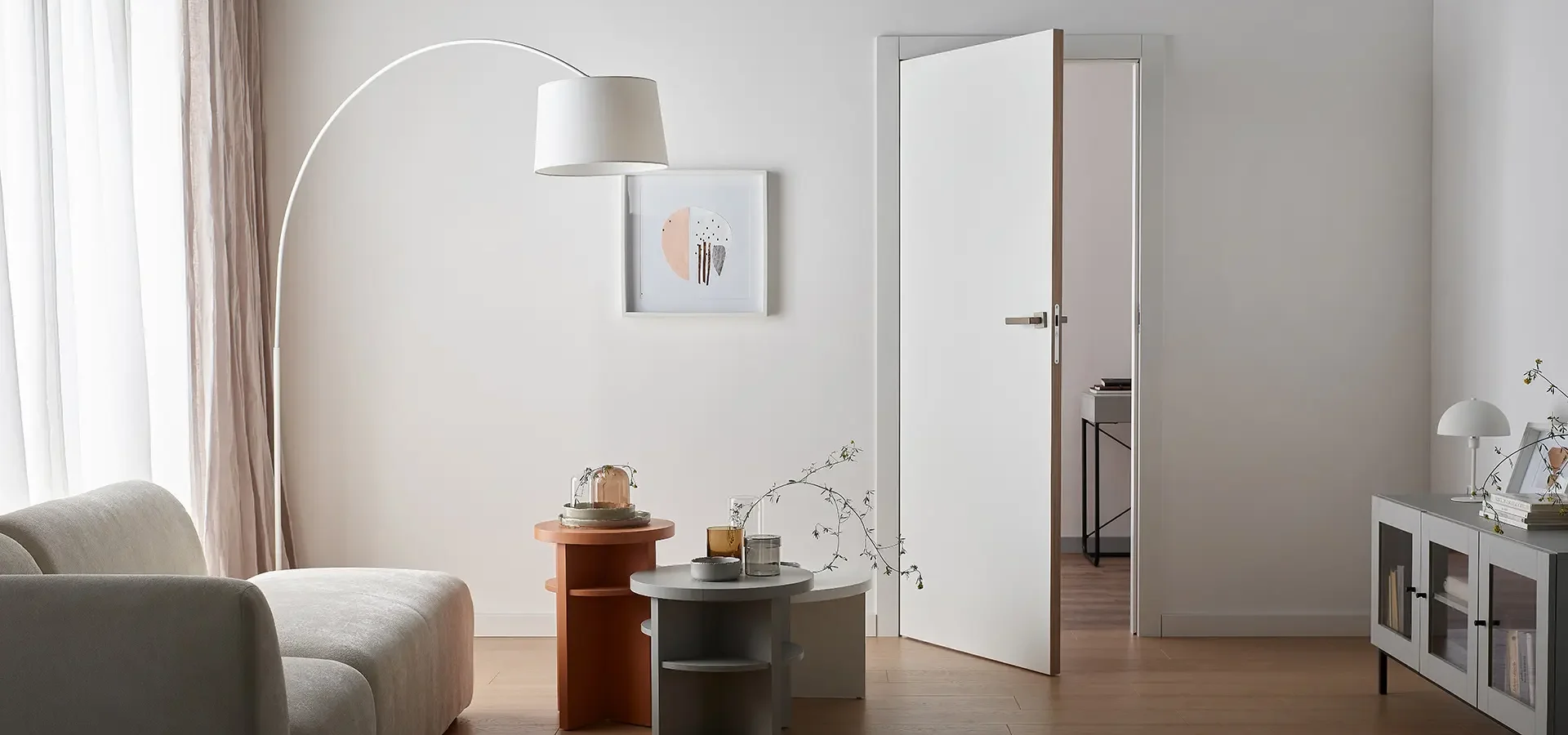 Białe drzwi z wąskim obrzeżem w minimalistycznym salonie